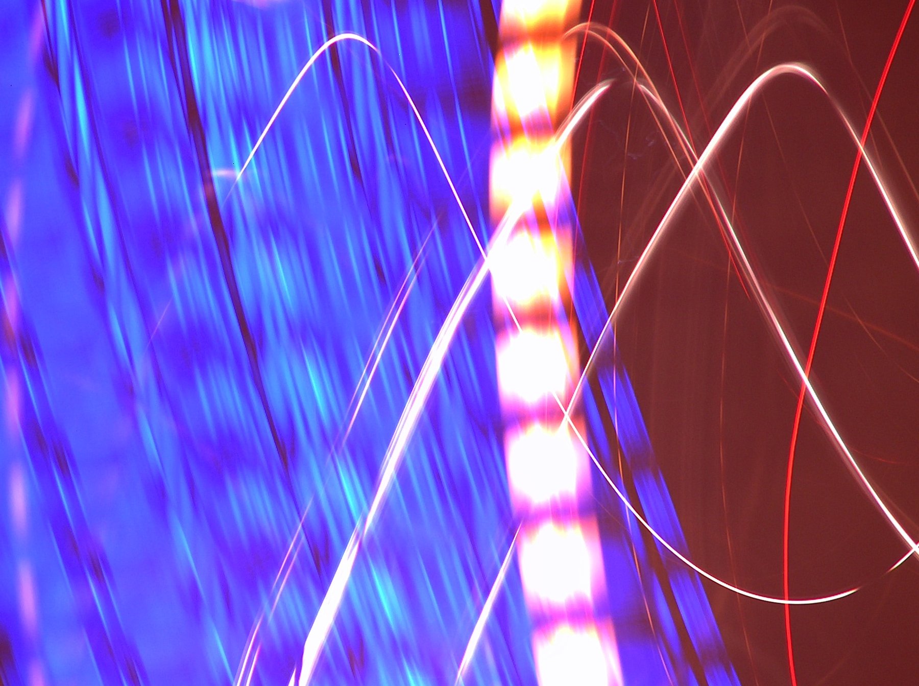 Blue and red lights with curved trails caused by camera movement.