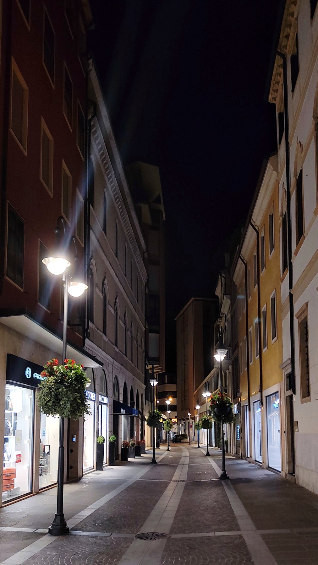 An illuminated street in Padua at night.