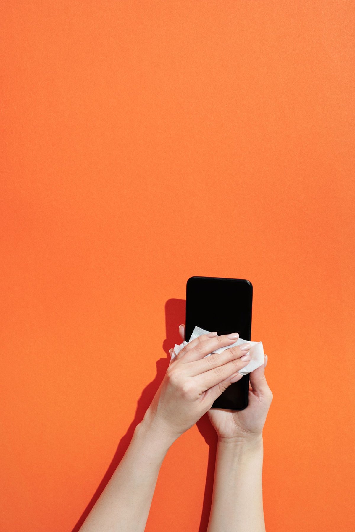 A smartphone being wiped with a cloth.