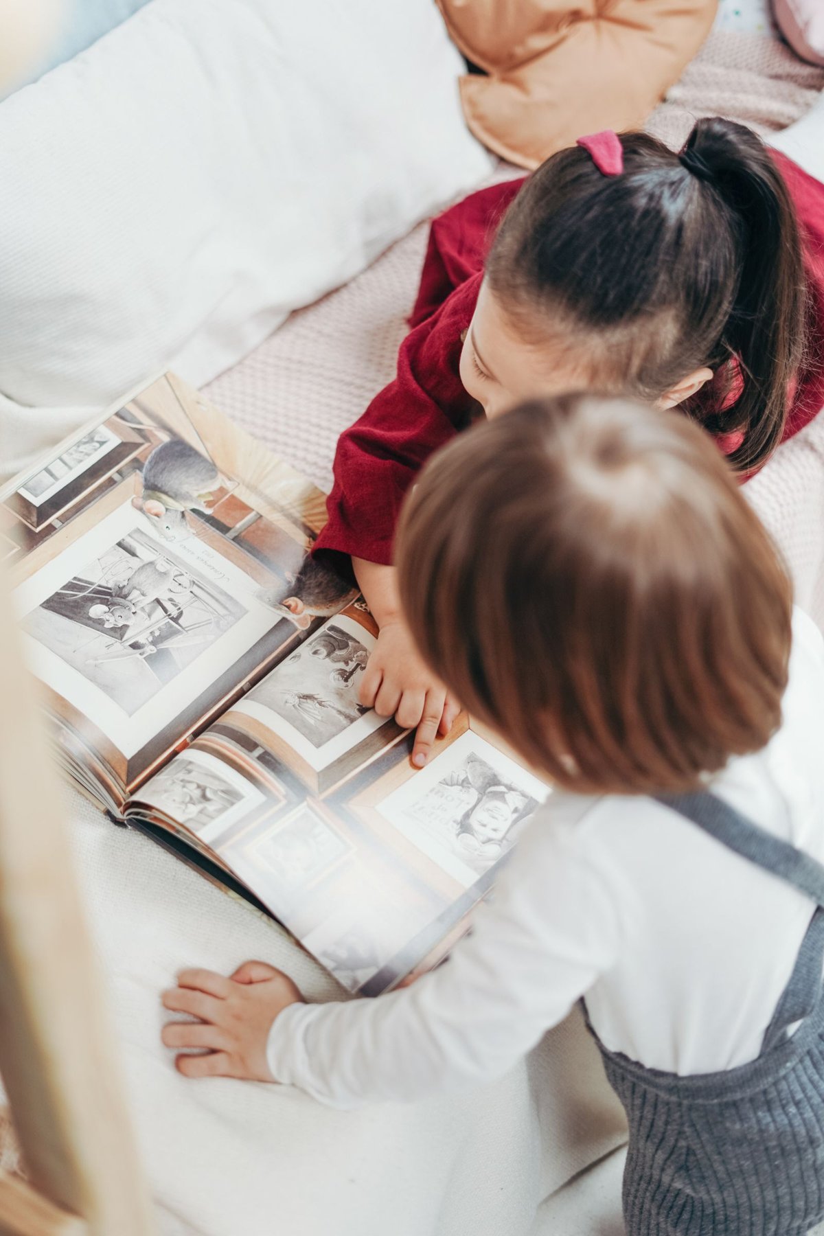 Children look through a photo book together.